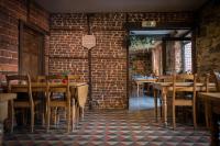 a restaurant with tables and chairs and a brick wall at Auberge de la Lesse in Celles