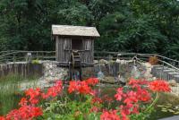 a garden with a bird house and red flowers at Forster Vadászkastély és Szálloda in Bugyi