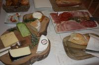 a table topped with different types of cheese and bread at La Villa d&#39;Olivène in Cuers
