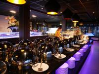 ein langer Tisch mit Tellern und Schüsseln darauf in einem Restaurant in der Unterkunft Hotel het Oosten in Alphen aan den Rijn