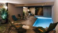 a pool in a hotel with chairs and a swimming pool at Citta di Lume Suites &amp; Lofts in Porto-Vecchio