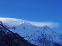 a snow covered mountain range with a cloudy sky at Auberge du Manoir in Chamonix