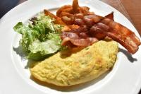 a white plate with an omelet and bacon and salad at Hotel Intrendy in Taishan