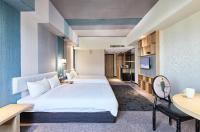 a hotel room with two beds and a desk at Kenting City Gate Hotel in Hengchun South Gate