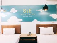 a bedroom with two beds and a sign that says see have a good day at S&amp;E Hotel in Tainan