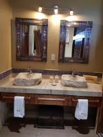 a bathroom with two sinks and two mirrors at Casa Arcoiris Zihuatanejo B&B in Zihuatanejo