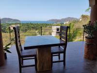 a wooden table and two chairs on a patio at Casa Arcoiris Zihuatanejo B&B in Zihuatanejo