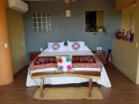 a bedroom with a large bed with pillows on it at Casa Arcoiris Zihuatanejo B&B in Zihuatanejo