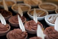 a bunch of chocolate cupcakes with white candles on them at Herods Palace Hotels & Spa Eilat a Premium collection by Fattal Hotels in Eilat