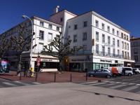 a city street with cars parked in front of buildings at Crystal Hotel in Royan