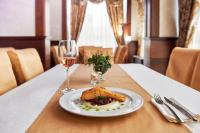 ein Teller mit Essen auf einem Tisch mit einem Glas Wein in der Unterkunft Platinum Image Hotel in Elin Pelin