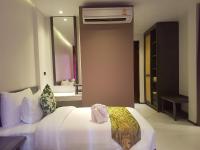a bedroom with a white bed and a mirror at Maehaad Bay Resort - SHA Plus in Mae Haad