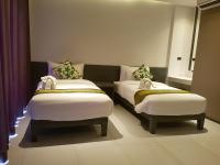 a room with two beds in a room with a window at Maehaad Bay Resort - SHA Plus in Mae Haad