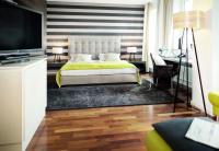 Un dormitorio con una cama grande y un televisor. en City Hotel Bosse, en Bad Oeynhausen
