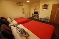 two beds in a room with red and white sheets at Taichung Xinshe Garden Life Homestay B&amp;B in Xinshe