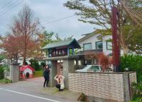 two women standing in front of a house at Chun Feng Cao Tang Homestay in Yuanshan