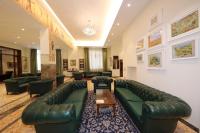 una gran sala de estar con un sofá de cuero verde en Hotel Moderno, en Siena