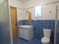 a blue tiled bathroom with a toilet and a sink at Vaintan B&amp;B in Dragey