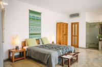a bedroom with a bed and two tables and a window at Highland Villa in Weligama