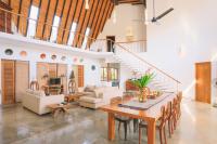 a living room with a table and chairs and a staircase at Highland Villa in Weligama