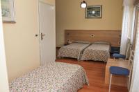 Un dormitorio con dos camas y una mesa y una silla. en Al Ponte della Vittoria, en Belluno