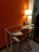 a glass desk with a chair and a lamp at Baan Baimai Boutique Room in Phra Nakhon Si Ayutthaya