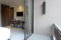 a room with a sliding glass door with a desk at Maehaad Bay Resort - SHA Plus in Mae Haad