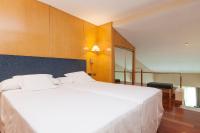 A bed or beds in a room at URH Ciutat de Mataró