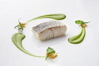 a piece of meat and vegetables on a white background at Eurostars Madrid Tower in Madrid