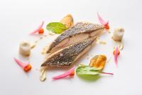 a piece of fish on a white plate with vegetables at Eurostars Madrid Tower in Madrid