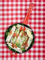 Una sartén con comida sobre una mesa con una espátula. en Mama Shelter Marseille, en Marsella