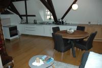 a kitchen and living room with a wooden table and chairs at appartement à Colmar in Colmar