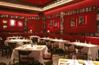 a restaurant with white tables and chairs and red walls at Planet Hollywood Resort & Casino in Las Vegas