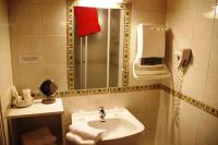 a bathroom with a sink and a shower and a phone at Hôtel des Chazes in Saint-Jacques-des-Blats