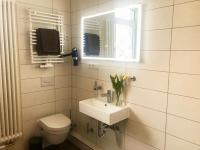 a bathroom with a sink and a toilet and a window at Pension Karina Schwerin in Schwerin