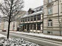 a snow covered city street with a building at Pension Karina Schwerin in Schwerin
