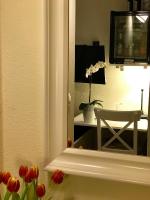 a mirror in a room with a chair and a desk at Pension Karina Schwerin in Schwerin