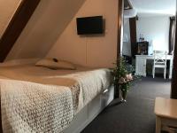 a bedroom with a bed with a tv on the wall at Pension Karina Schwerin in Schwerin