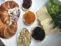 a white plate topped with different types of bread and cheese at Pension Karina Schwerin in Schwerin