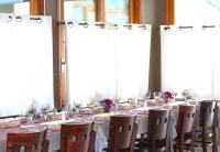 une longue table avec des chaises et des verres à vin dans l'établissement Domaine de Sainte-Croix, à Sainte-Croix