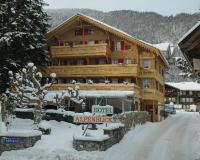 un gran edificio de apartamentos de madera en la nieve en Alpenblick Hotel &amp; Restaurant Wilderswil by Interlaken, en Wilderswil