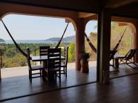 a dining room with a table and chairs on a porch at Casa Arcoiris Zihuatanejo B&B in Zihuatanejo