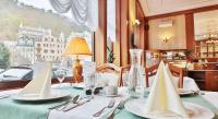 a table with plates and napkins on a table in a restaurant at Olympia Wellness Hotel in Karlovy Vary