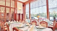 a dining room with tables and chairs and windows at Olympia Wellness Hotel in Karlovy Vary