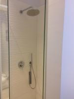 a shower with a glass door with a shower head at ChilloutOostende in Ostend