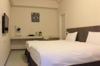 a bedroom with a large white bed and a table at Sunnyside Hotel in Kaohsiung