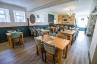 a dining room with wooden tables and chairs at The Torfin in Edinburgh
