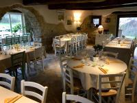 Un comedor con mesas y sillas blancas. en Agriturismo Fonte Rosa, en Fiastra