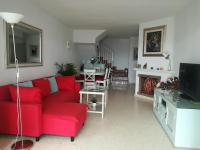 a living room with a red couch and a tv at Casa Las Toro Playa in Chilches