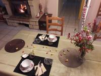 a living room with a table and a fireplace at La Nouste Maisoun in Barcelonne-du-Gers